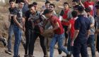 Homem ferido sendo carregado por manifestantes ao longo da cerca fronteiriça com Israel na Faixa de Gaza