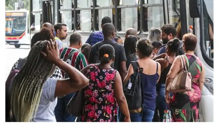 Trabalhadores encarando fila para ônibus