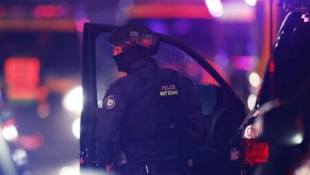 Um membro do Esquadrão de Choque da Polícia atende a ocorrência no local