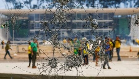 Manifestantes através de vidros quebrados no atentado golpista