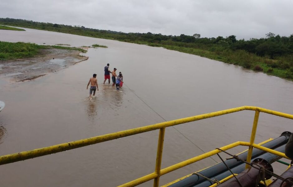 Com cordas, os ocupantes da embarcação ajudam no trajeto até a comunidade