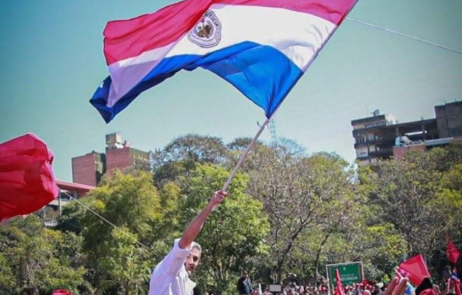 Mario Abdo levanta a bandeira do Paraguai durante manifestação