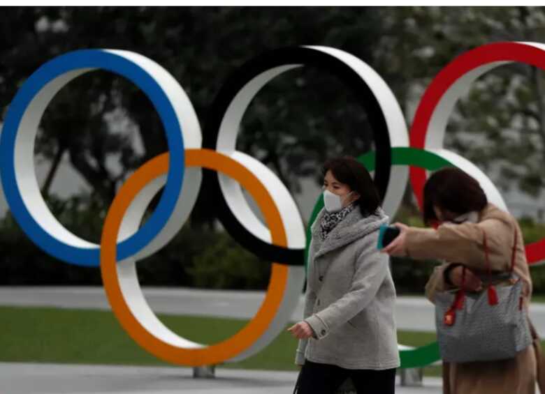 Pedestres caminham em frente a museu olímpico em Tóquio