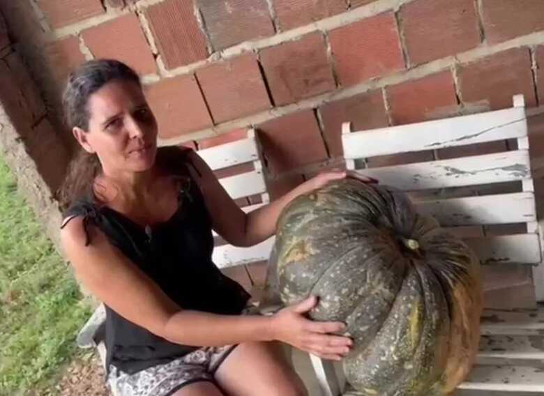 A agricultora V&acirc;nia Barros com jerimum gigante de mais de 35 kg