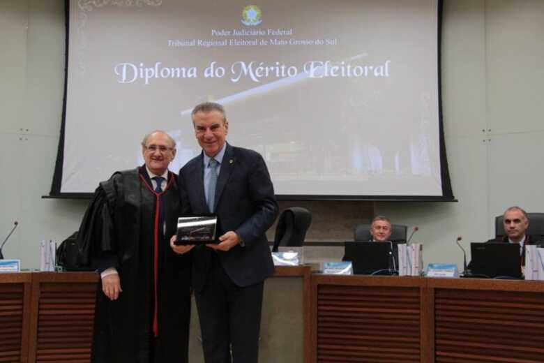 Presidente da ALEMS, Paulo Corrêa, recebendo honraria das mãos do presidente do TRE-MS, Desembargador Paschoal