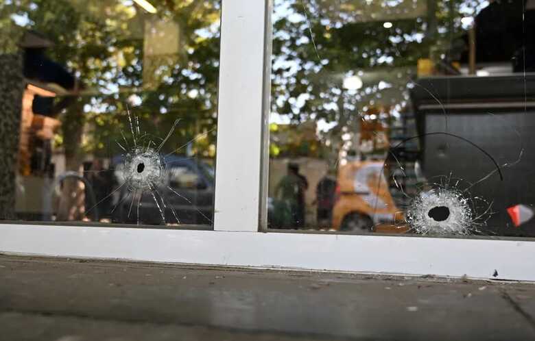 Buracos de tiros são vistos nos vidros do mercado da família da esposa de Messi