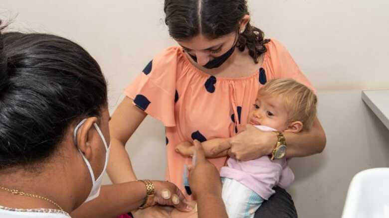 Bebê sendo vacinado nem unidade de saúde