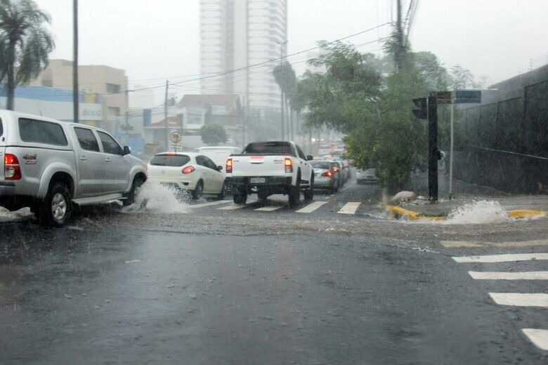 Carros no trânsito durante chuva forte em Campo Grande