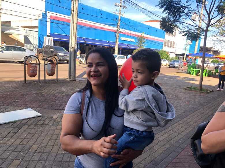 Eladir da Silva, junto do neto, para quem procurava roupas de frio nesta manh&atilde;. 