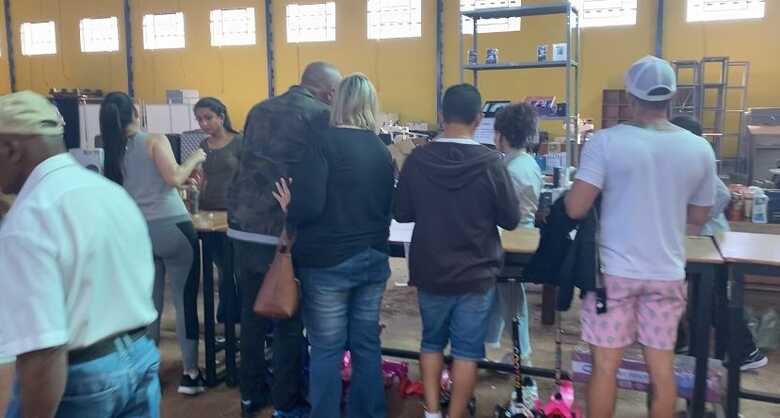 Pessoas comprando mercadorias no bazar da Apae.
