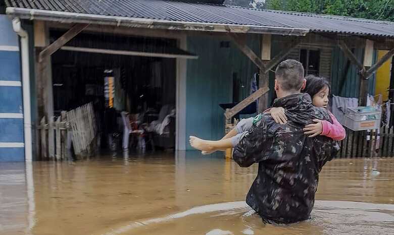 Militar resgata crian&ccedil;a de casa inundada