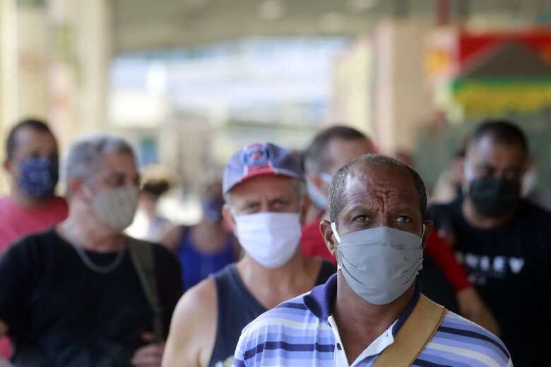 Pessoas circulando com máscaras devido a Covid