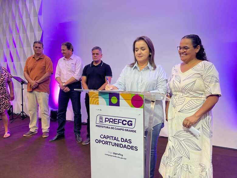Prefeita assinando documento