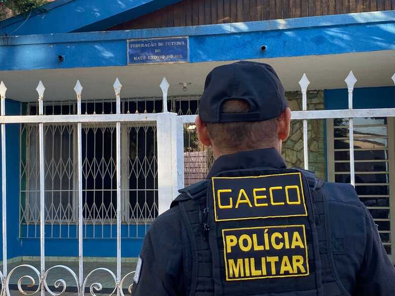 Agente do Gaeco espera a chegada de outras equipes para entrar na sede