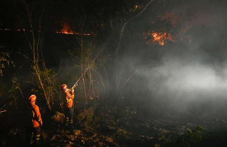 Um grupamento do Corpo de Bombeiros trabalha durante a noite protegendo os terrenos das chamas
