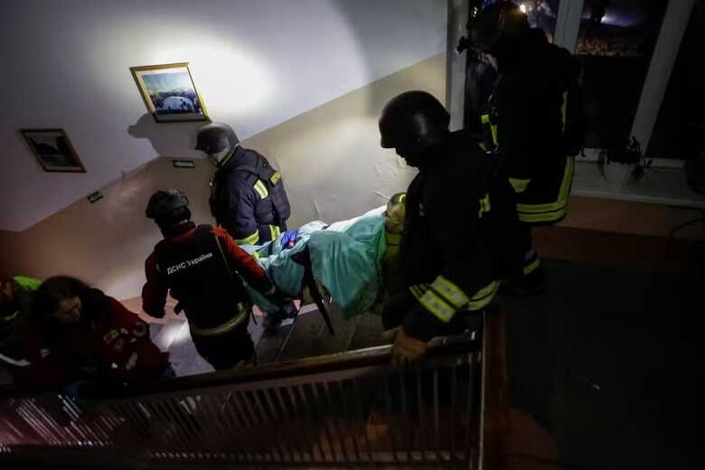 Socorristas e trabalhadores médicos evacuam uma pessoa de um hospital atingido por um ataque de drone russo, durante o ataque da Rússia à Ucrânia, em Kharkiv, na Ucrânia 