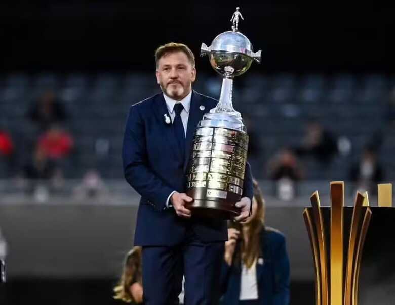 Alejandro Domínguez, presidente da Conmebol, carregando a taça da Libertadores 