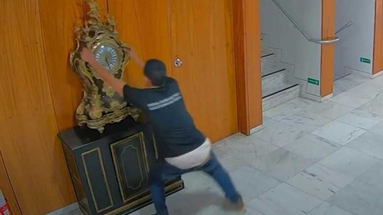 O mec&acirc;nico Ant&ocirc;nio Cl&aacute;udio Alves Ferreira quebrando o rel&oacute;gio hist&oacute;rico no 8 de Janeiro 