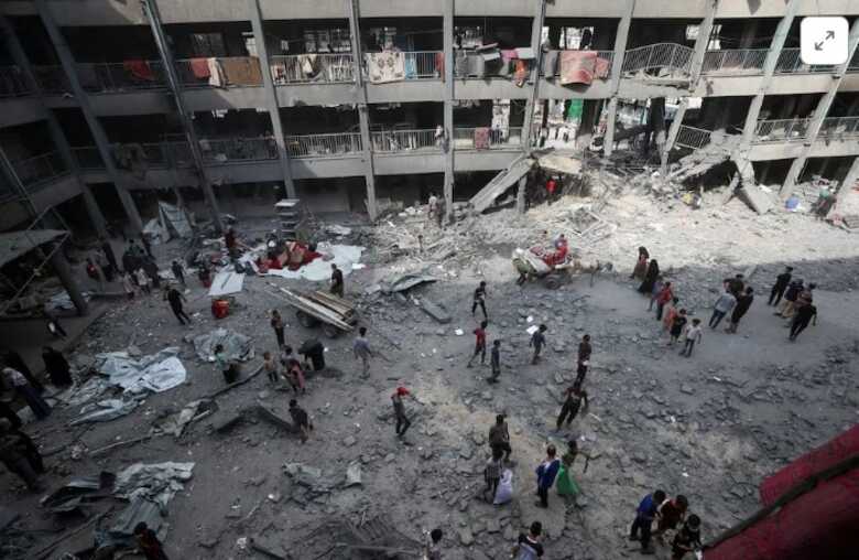 Palestinos inspecionam os danos em uma escola da UNRWA