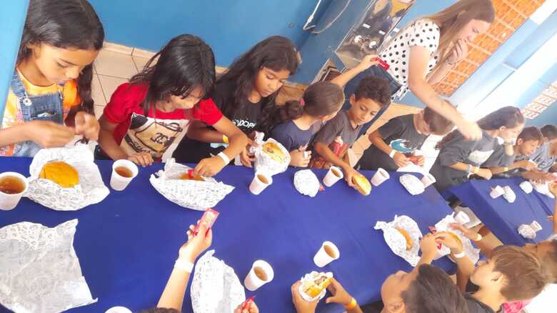 Crianças comendo hambúrgueres em ação passada. 
