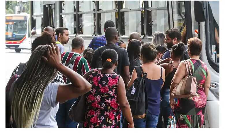 Trabalhadores encarando fila para ônibus