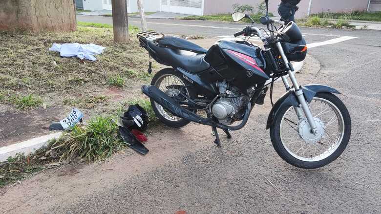 Motocicleta da v&iacute;tima e ao fundo, pano que serviu para cobrir o corpo
