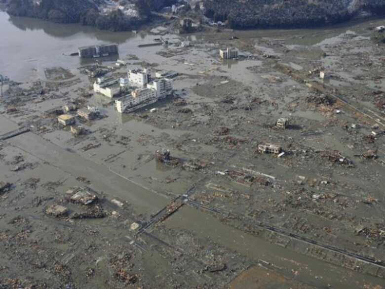 Imagem aérea da cidade portuária de Minamisanriku, coberta de lama após a passagem do tsunami, neste sábado (12) (Foto: AP)