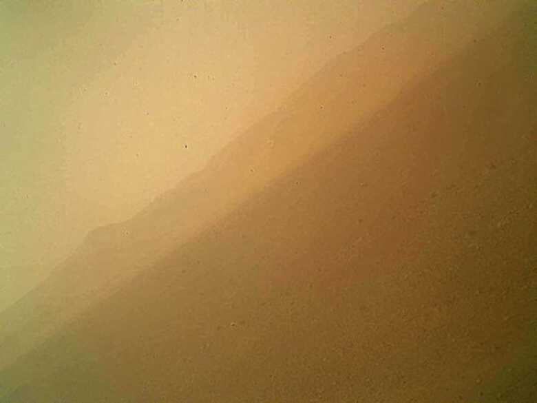 Imagem da câmera Mahli, situada no braço do Curiosity, foi tirada na tarde do primeiro dia após o pouso em Marte. No horizonte, fica a parte norte da Cratera Gale.