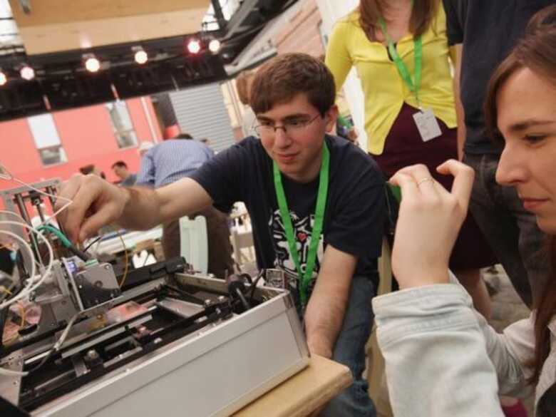 Estudante de engenharia mecânica do Massachusetts Institute of Technology (MIT) demonstra a operação de uma impressora 3D em laboratório na Alemanha.