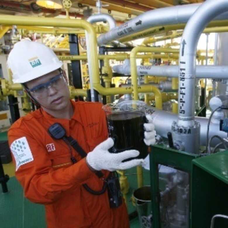 Funcionária da Petrobras exibe amostra de petróleo extraído da camada pré-sal, na plataforma marítima P34, em Vitória (ES).