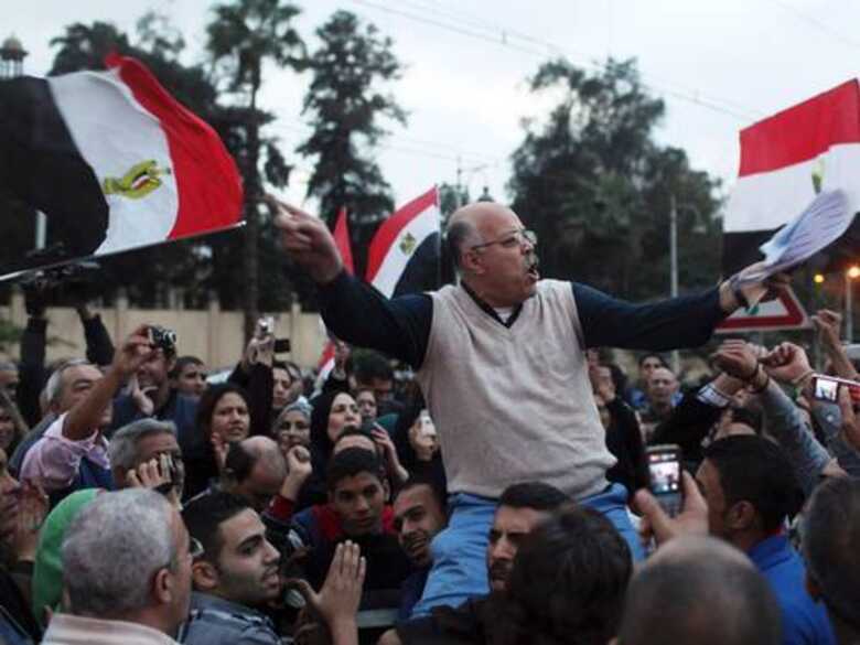 Manifestante da oposição segura bandeira do Egito em frente ao palácio presidencial .