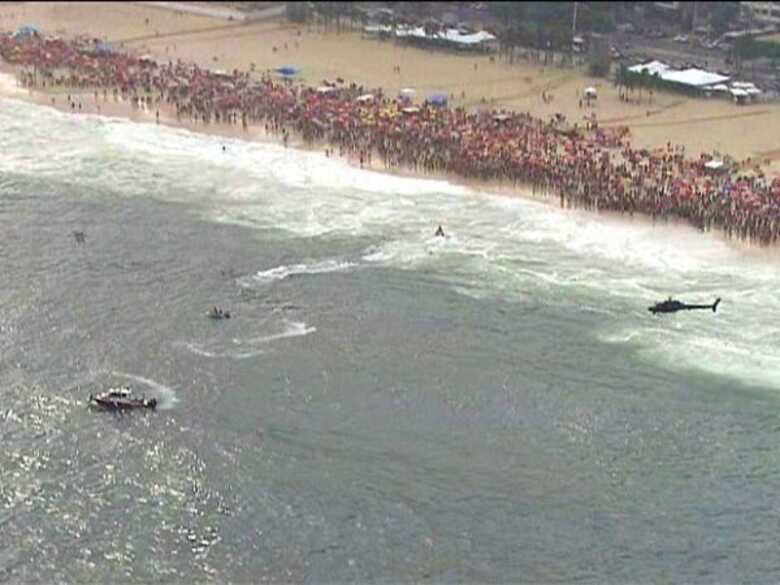 Equipes de socorro do Corpo de Bombeiros fazem as buscas ao helicóptero na Praia de Copacabana, neste sábado (29).