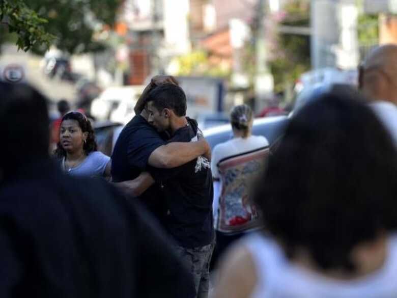 Parentes de vítimas do incêndio da boate Kiss se abraçam durante enterro em Santa Maria.