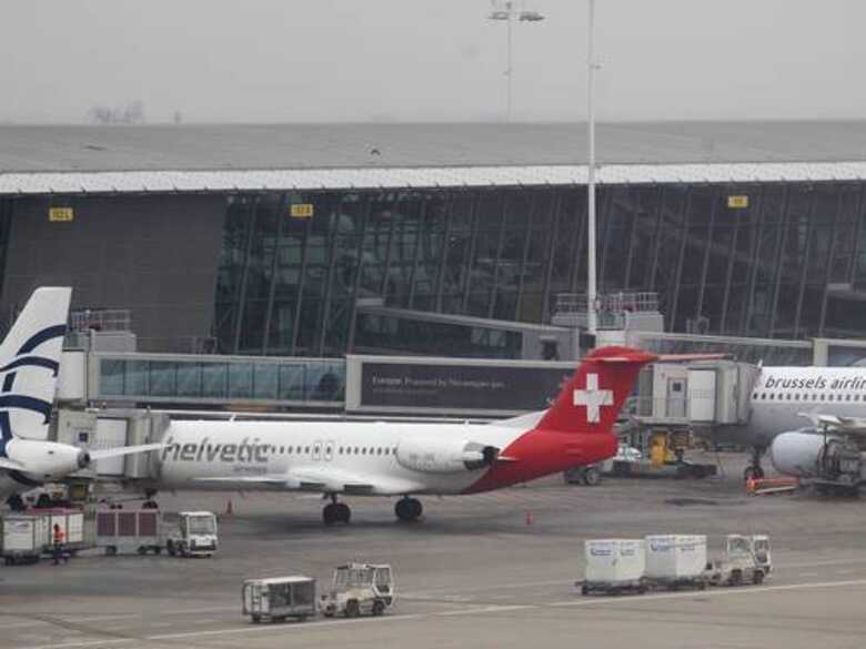 Carrinhos de bagagem passam por aeronave alvo do assalto de diamantes no aeroporto internacional de Bruxelas.