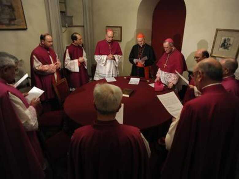 O cardeal Tarcisio Bertone (centro, de gorro vermelho) assume o posto de camerlengo após a renúncia de Bento XVI.