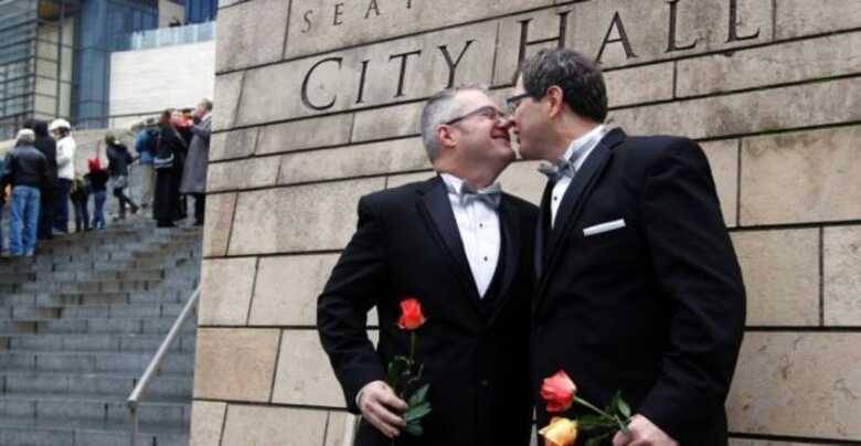 Terry Gilbert (à esq.) beija Paul Beppler, após o casamento, em Seattle, que os tornou um dos primeiros casais formais após Washington legalizar o casamento de pessoas do mesmo sexo.