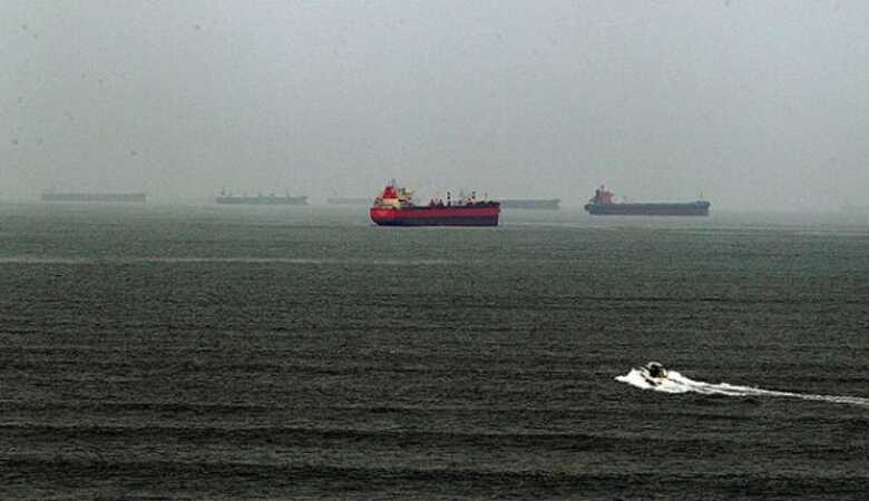 Estacionados em meio de neblina, navios na entrada do Porto de Santos esperam para atracar.