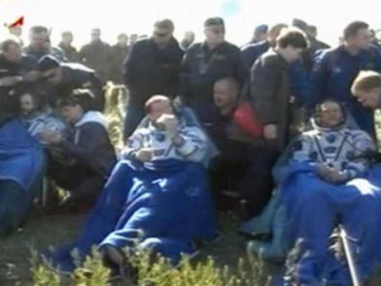 Astronautas da cápsula espacial recebem primeiros atendimentos.