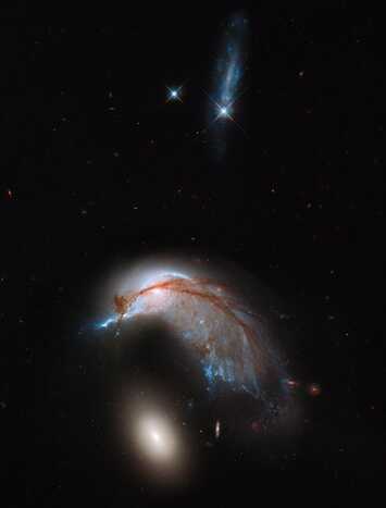 Imagem do telescópio Hubble mostra interação de galáxias conhecida como Arp 142, que lembra pinguim cuidando de ovo. (Foto: AFP/NASA-ESA Hubble Heritage)