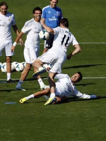 Durante momento descontra&iacute;do do treino, Cristiano Ronaldo arriscou um carrinho em Bale. (Foto: Reuters)