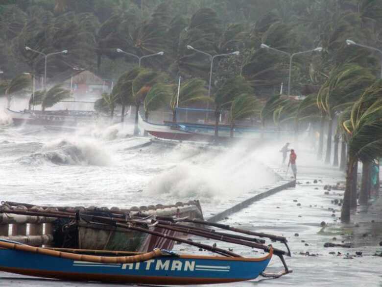 Em Albay, moradores observam as ondas gigantes que se formam com a chegada do tufão. (Foto: AFP)