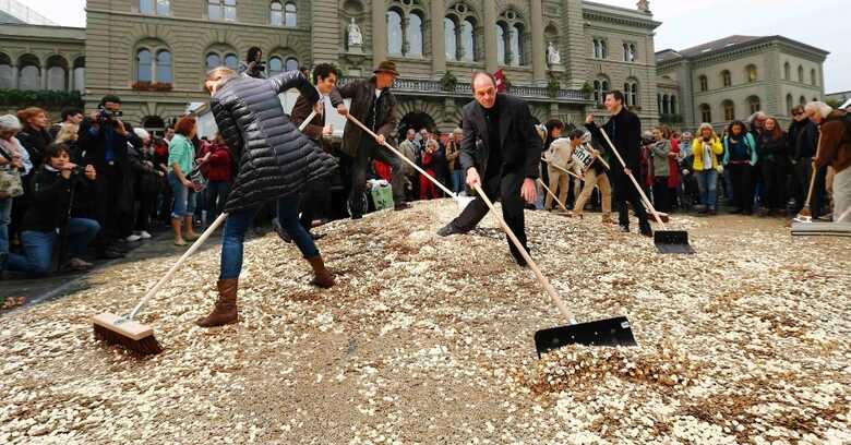 Voluntários espalharam moedas de cinco centavos em evento da campanha para que o governo Suíço garanta uma renda mínima. (Foto: Denis Balibouse/Reuters)