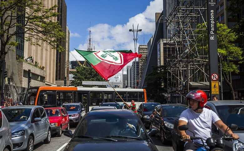 Torcedor da Portuguesa acena com bandeira na avenida Paulista, que teve três faixas bloqueadas por manifestação. (Foto: Apu Gomes/Folhapress)