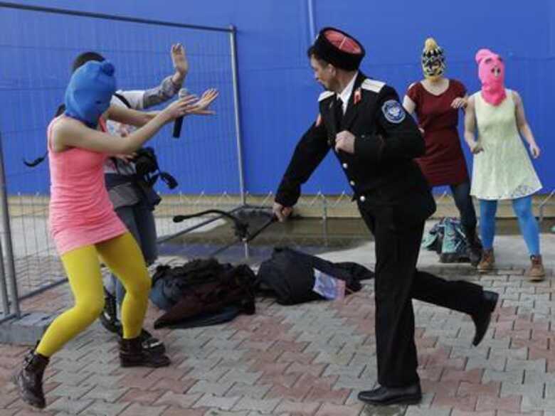 Integrantes da banda punk Pussy Riot são agredidas por guardas, em Sochi. (Foto: AP)