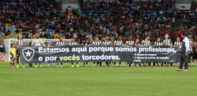 Jogadores do Botafogo estendem faixa de protesto contra atraso de sal&aacute;rios. (Foto: Roberto Filho/Fotoarena)