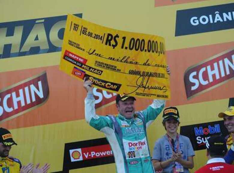 Rubens Barrichello levanta cheque simbólico da Corrida do Milhão. (Foto: Duda Bairros/Vicar/divulgação)