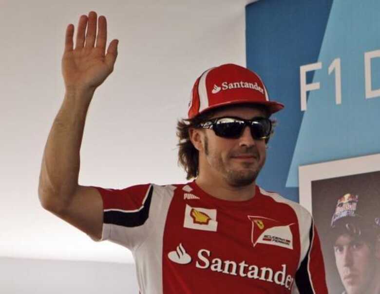 Fernando Alonso acena para os fãs antes de sessão de autógrafos em Abu Dhabi. (Foto: Kamran Jebreili/AP)