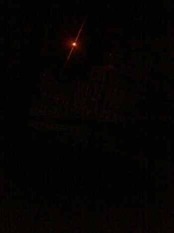 Uma foto da varanda de casa e outra que mostra a única lâmpada acesa, ao longe