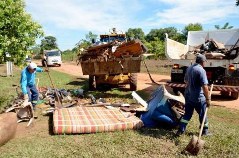 Equipes da secretaria de obras recolhendo objetos destruídos pela enchente