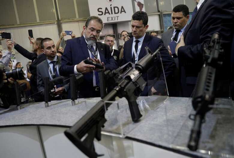 Presidente da indústria Taurus, Salésio Nuhs, mostra armas ao ministro da Justiça e Segurança Pública, Sergio Moro, no estande da empresa durante a Laad